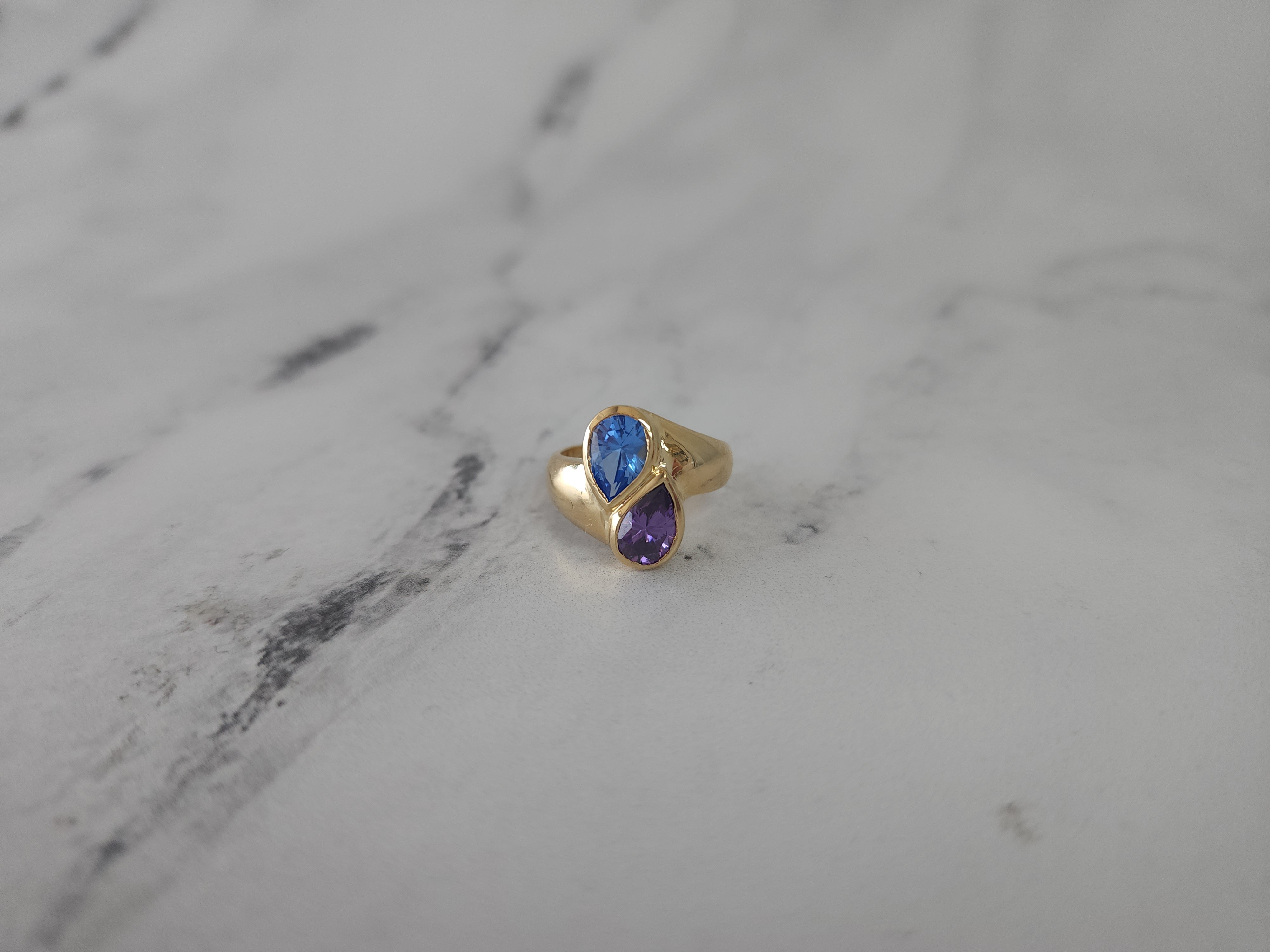 Anillo en forma de pera con topacio azul y amatista