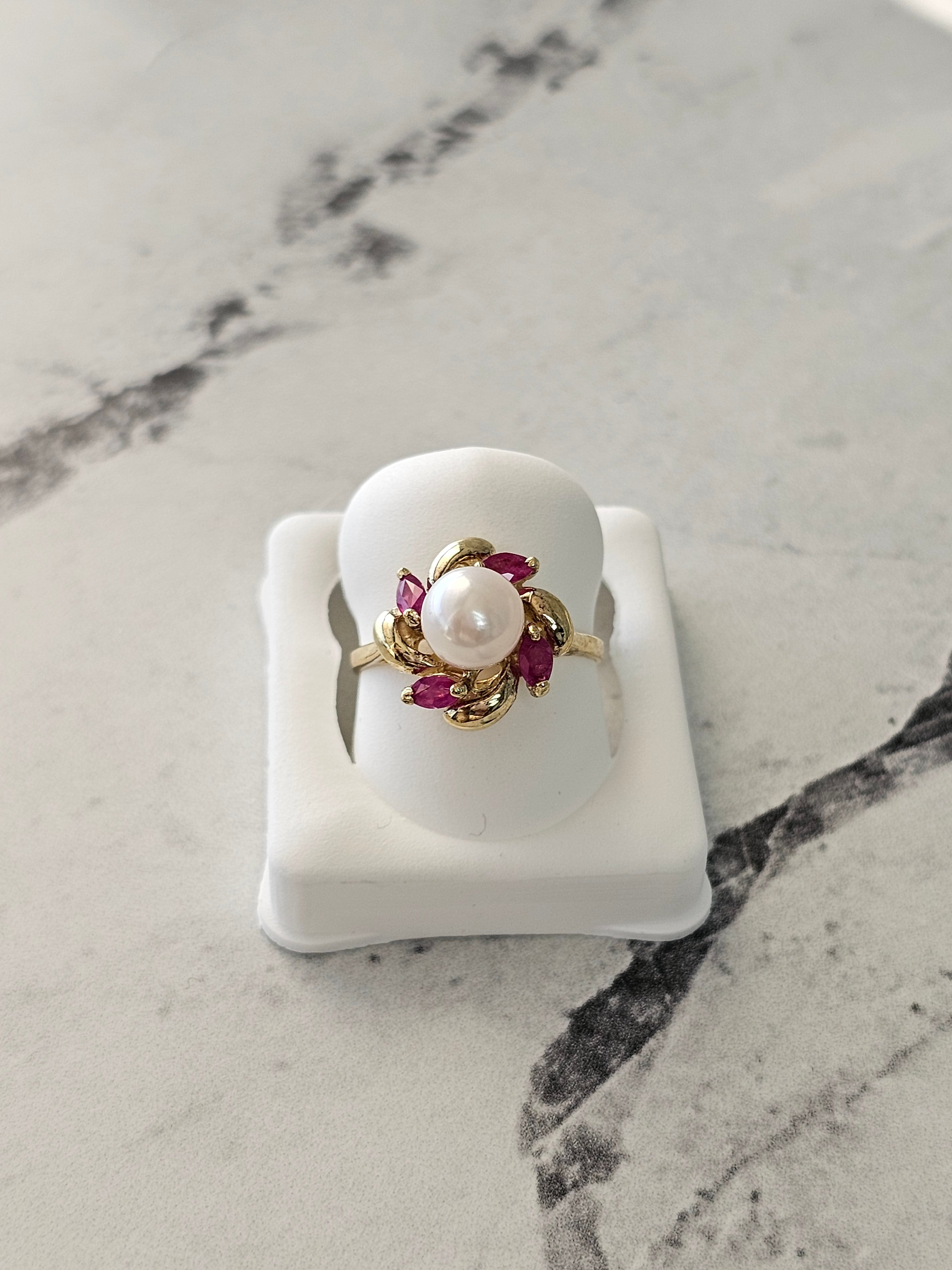 Anillo con centro de perla y detalle de rubí marquesa en oro amarillo de 14 k