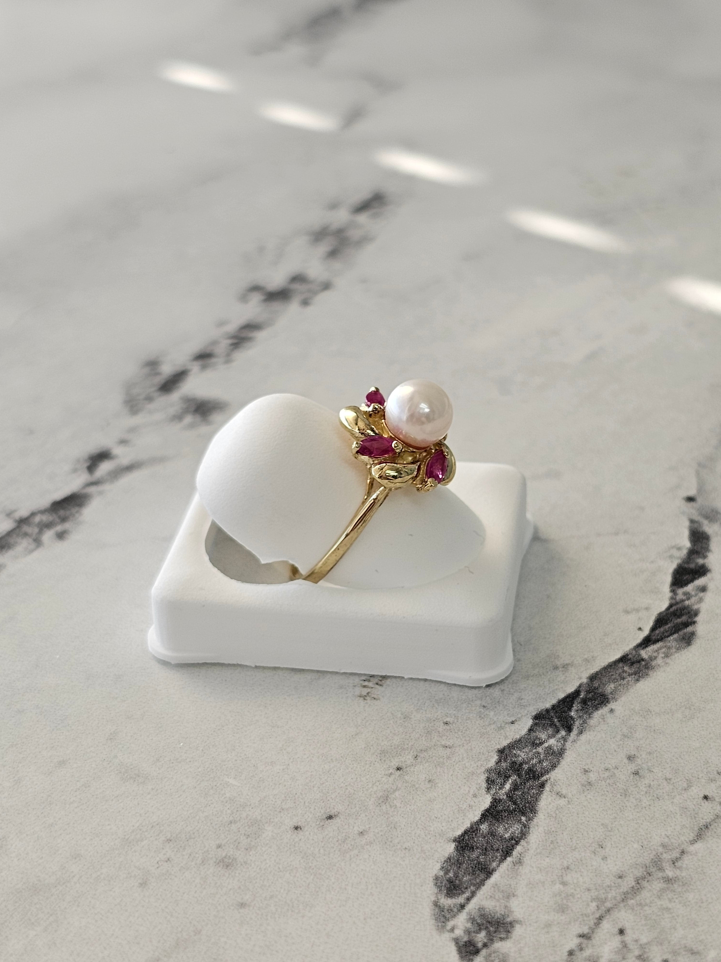 Anillo con centro de perla y detalle de rubí marquesa en oro amarillo de 14 k