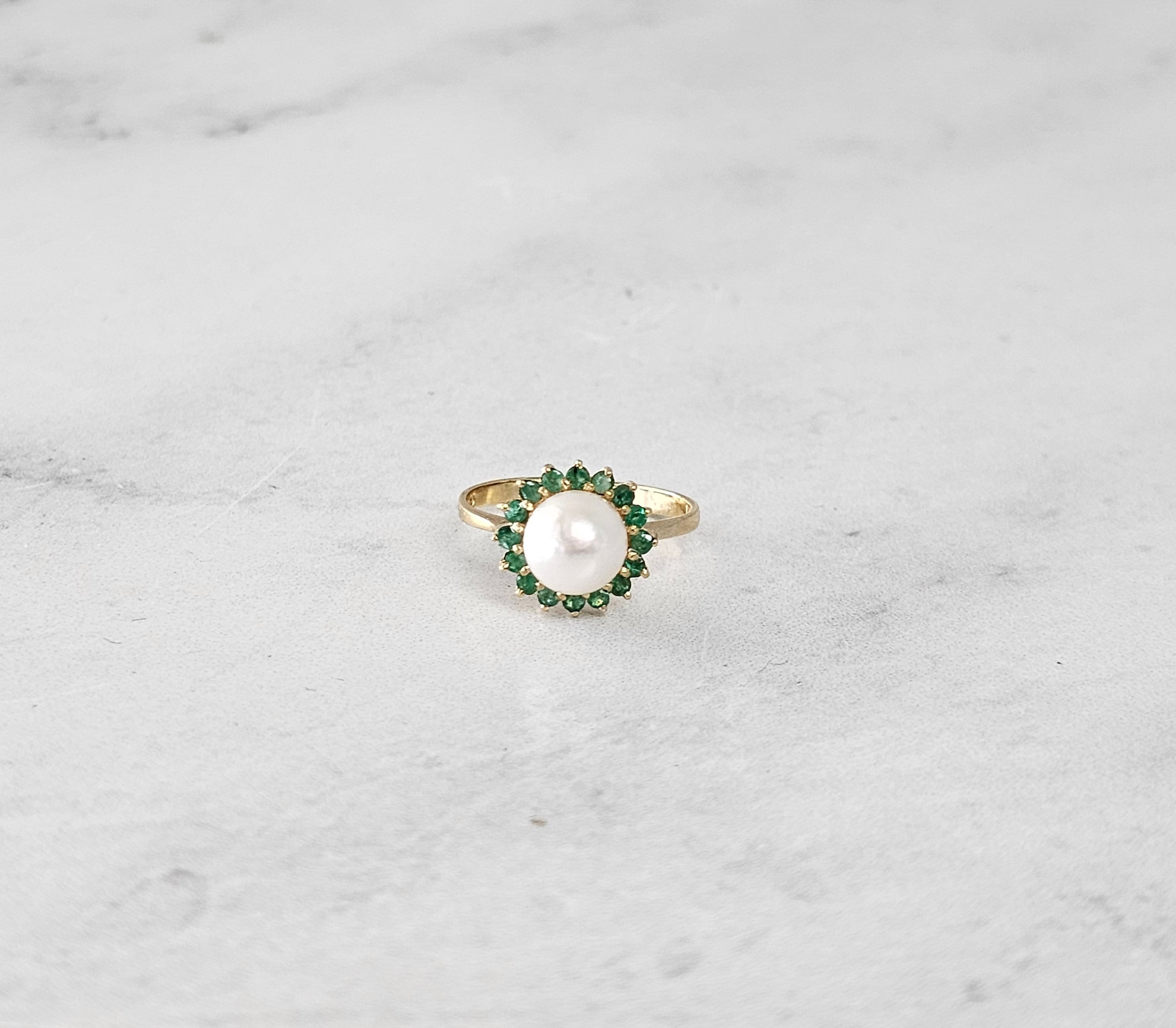 Anillo con halo de perla y esmeralda en oro amarillo de 14 k