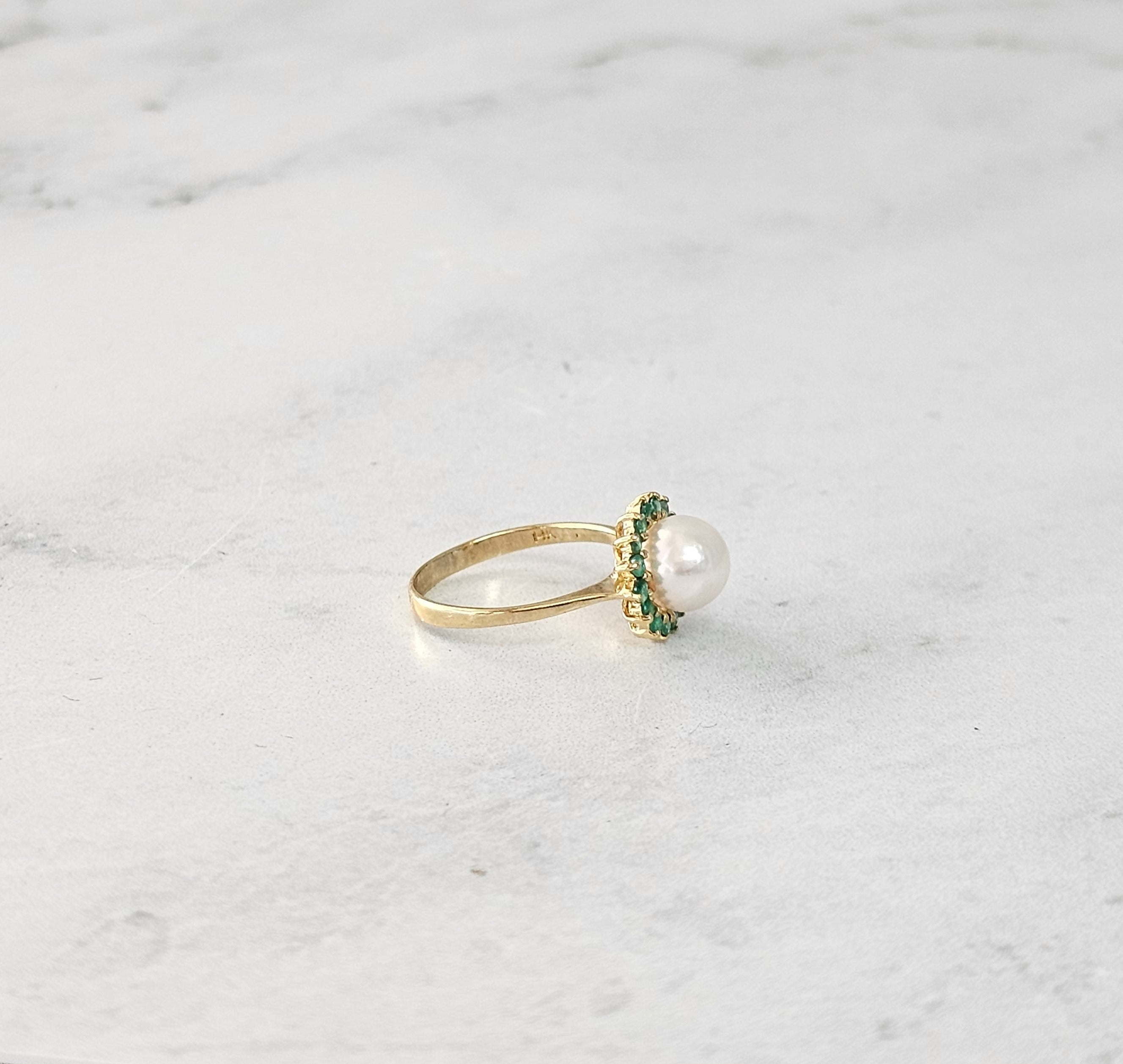 Anillo con halo de perla y esmeralda en oro amarillo de 14 k