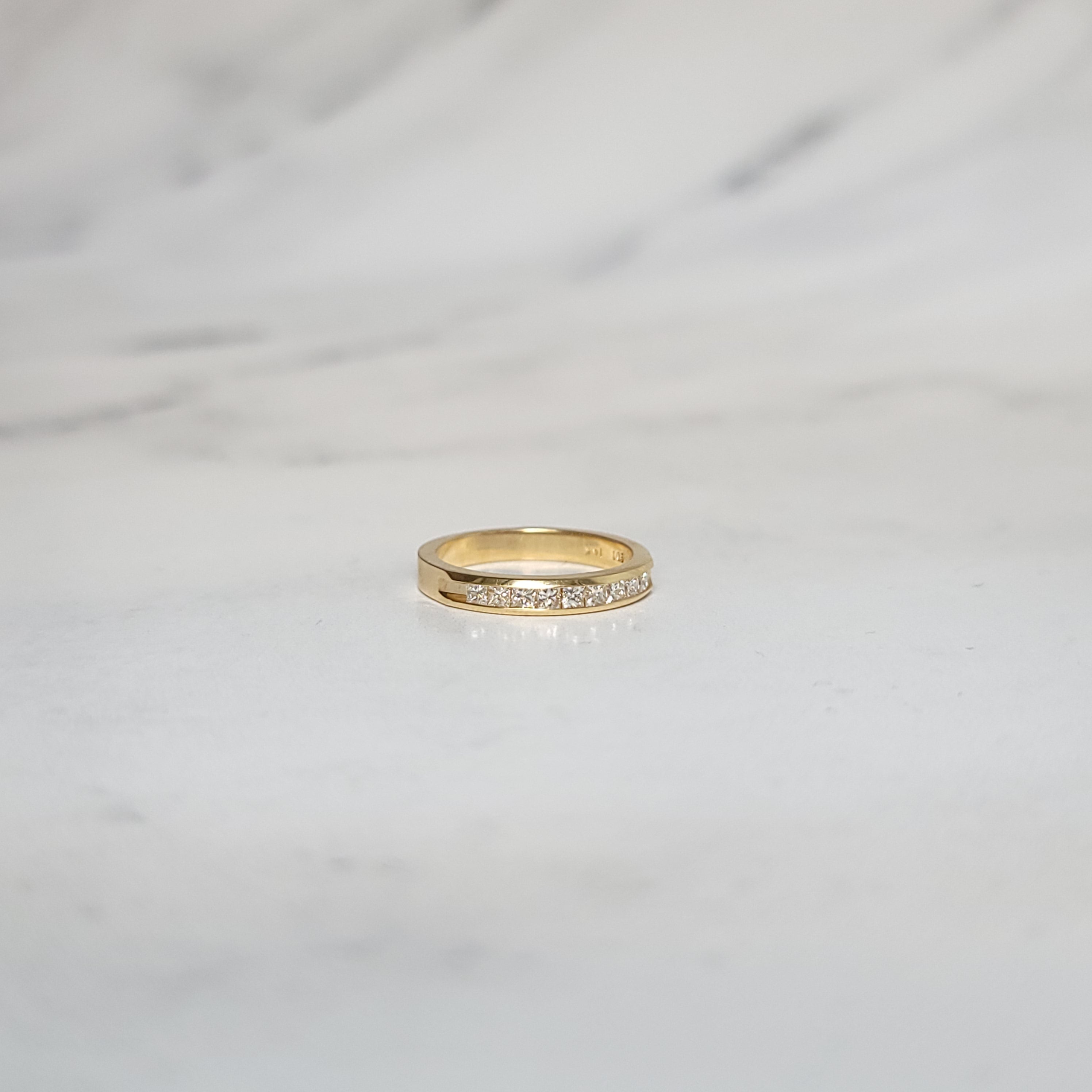Alianza de boda con diamantes en canal de talla princesa