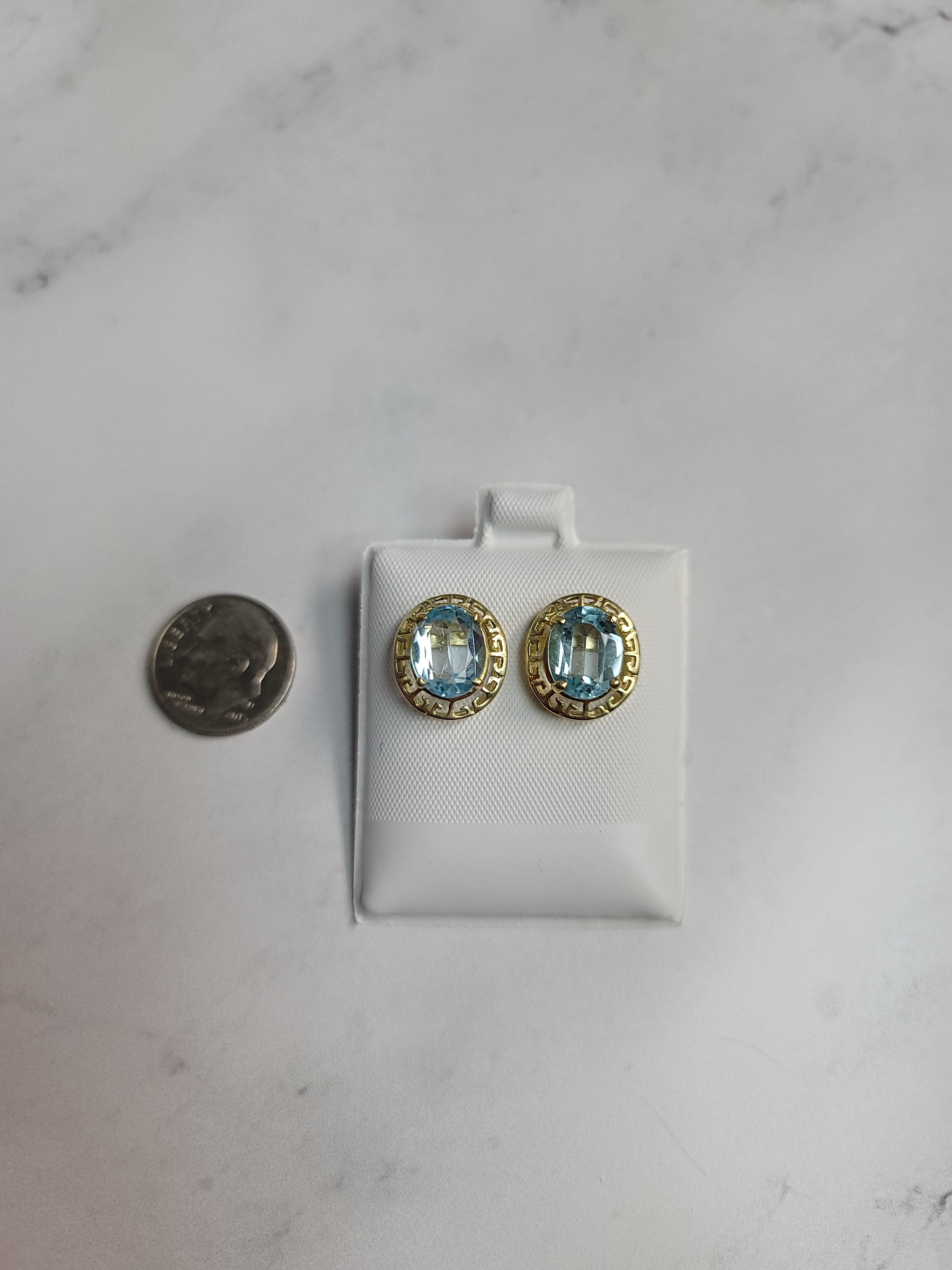 Pendientes de topacio azul ovalado con marco de bisel griego de oro amarillo de 14 k