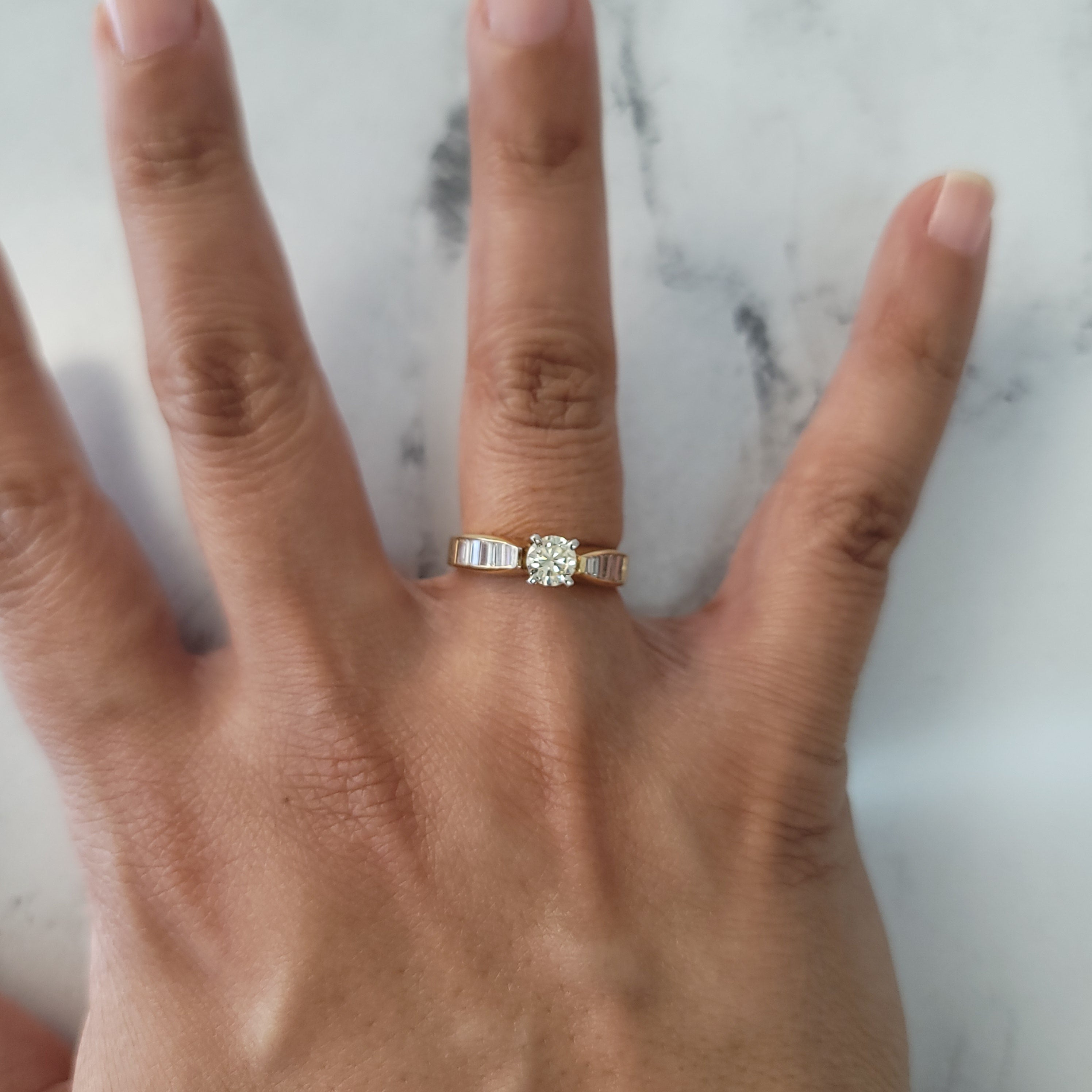 Anillo de compromiso con solitario de un quilate y diamantes con detalles en talla baguette