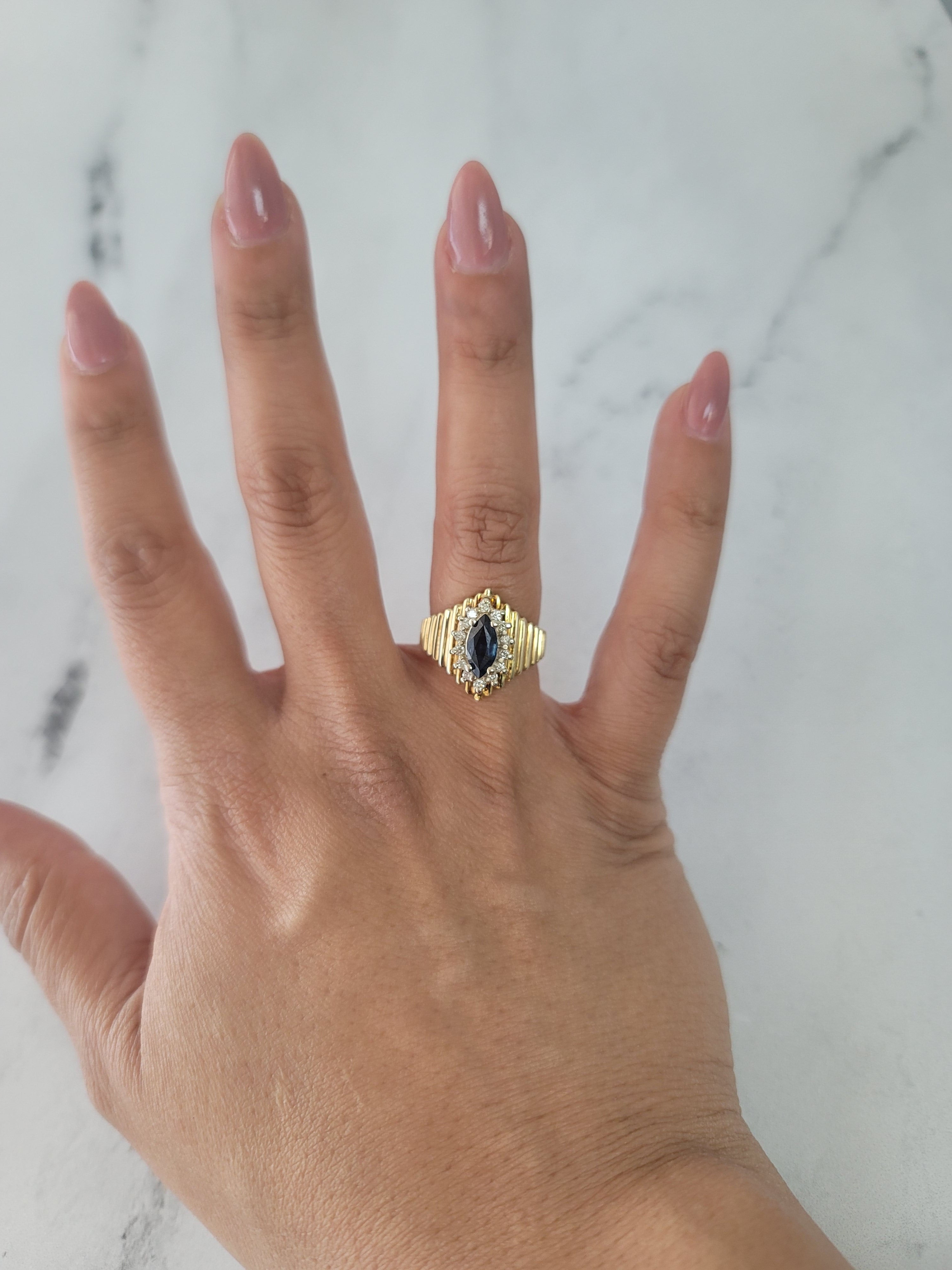 Zafiro marquesa con halo de diamantes en una exclusiva banda de oro amarillo de 14 k